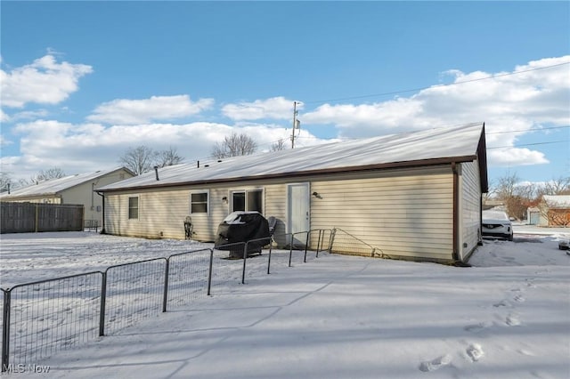 snow covered house with fence