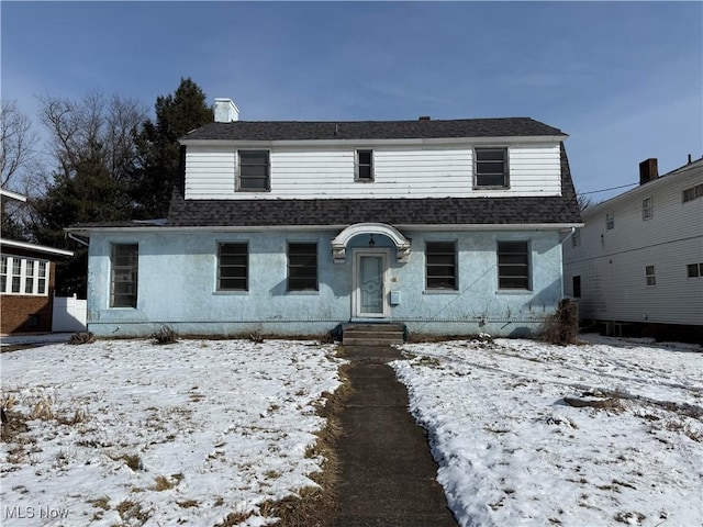 dutch colonial with a shingled roof and stucco siding