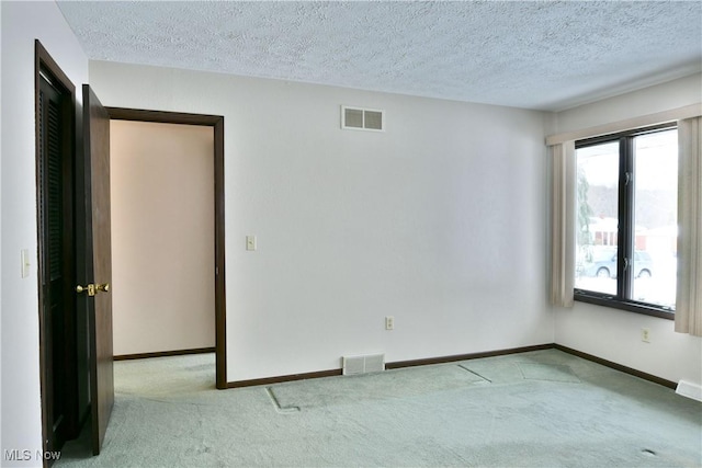 unfurnished room featuring light carpet, visible vents, and baseboards