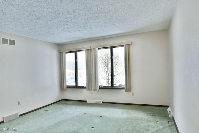 empty room featuring light colored carpet, visible vents, and baseboards