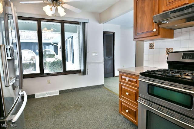 kitchen with visible vents, brown cabinets, stainless steel appliances, carpet flooring, and under cabinet range hood