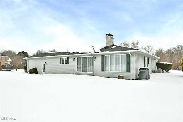 snow covered property with a chimney