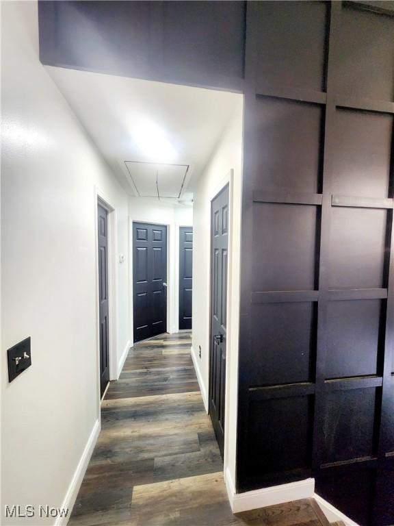 hall featuring attic access, dark wood finished floors, and baseboards