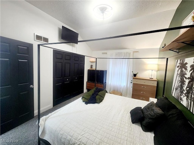 bedroom with lofted ceiling, carpet flooring, visible vents, and a textured ceiling