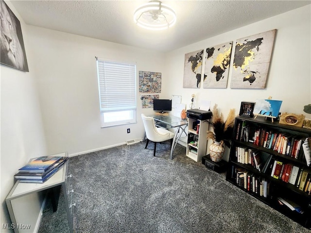 office space featuring a textured ceiling, dark carpet, and baseboards