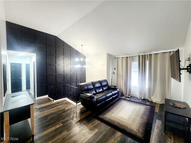 living area featuring lofted ceiling, wood finished floors, and baseboards