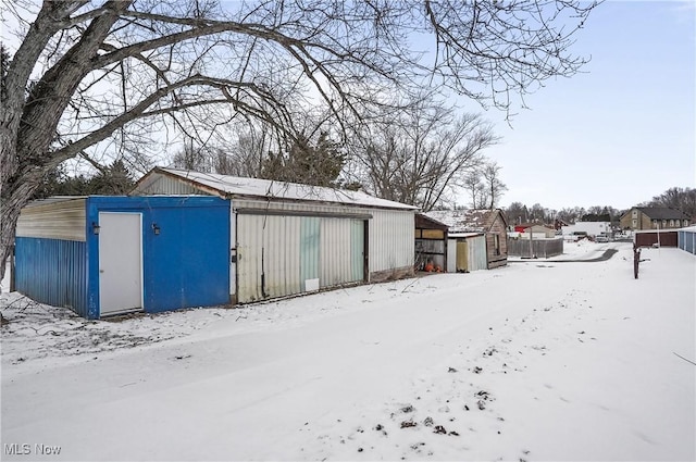 snow covered structure with fence