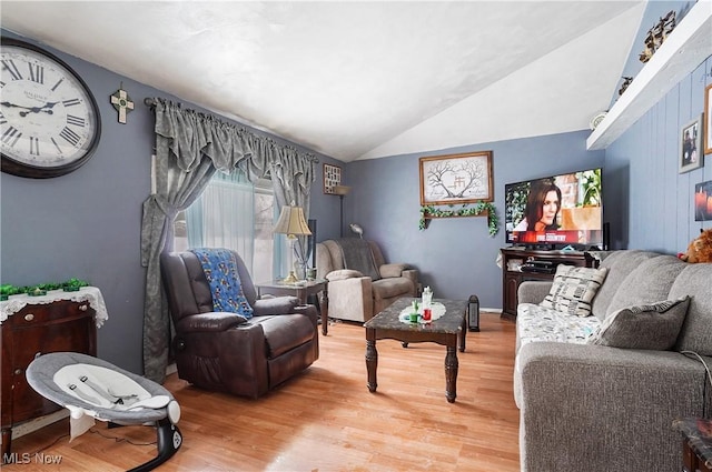 living area featuring lofted ceiling and wood finished floors