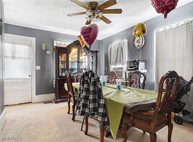 dining space with cooling unit, light colored carpet, a ceiling fan, visible vents, and crown molding