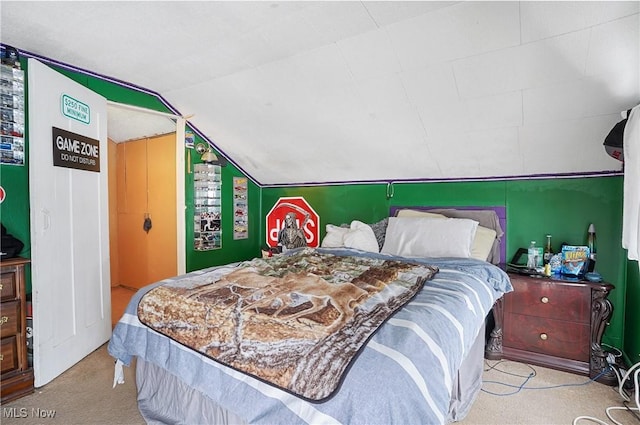 bedroom with vaulted ceiling and light colored carpet