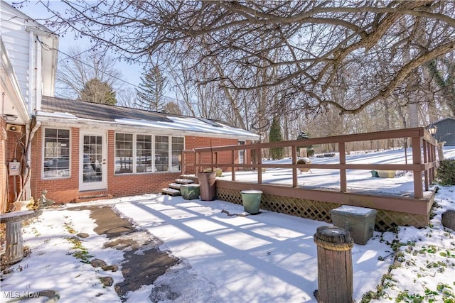 snow covered patio with a deck