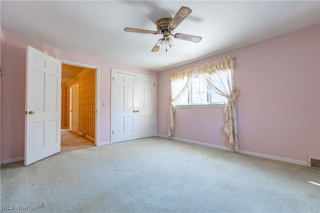 unfurnished bedroom featuring a closet, visible vents, a ceiling fan, carpet flooring, and baseboards