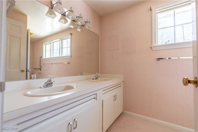 full bathroom featuring double vanity, baseboards, and a sink