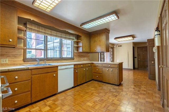 kitchen featuring dishwasher, a peninsula, a sink, and open shelves