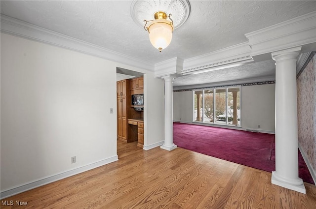 unfurnished room with ornamental molding, light wood-type flooring, a textured ceiling, and ornate columns