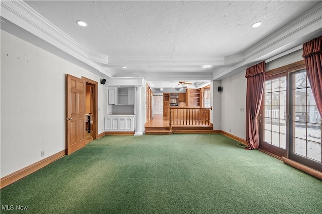 carpeted spare room featuring a raised ceiling, crown molding, a textured ceiling, and baseboards