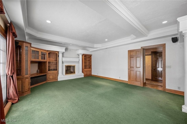 unfurnished living room with carpet floors, a tray ceiling, a fireplace, and baseboards