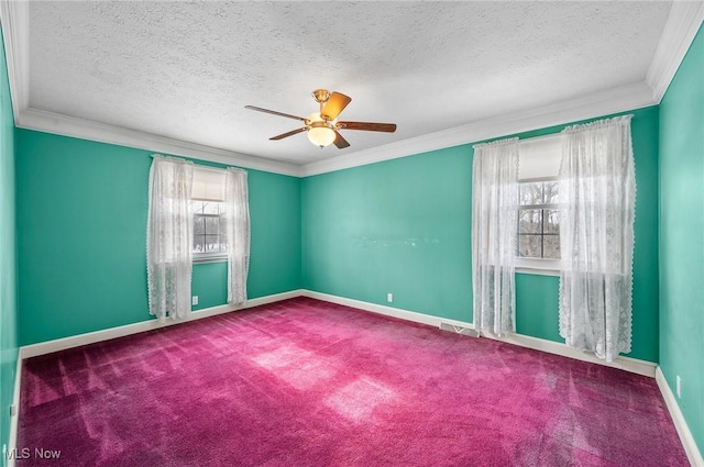 carpeted empty room with ceiling fan, ornamental molding, visible vents, and baseboards