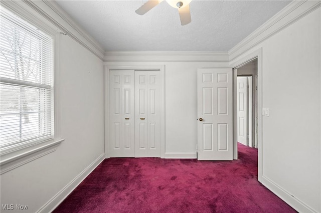 unfurnished bedroom featuring baseboards, ornamental molding, carpet, a textured ceiling, and a closet