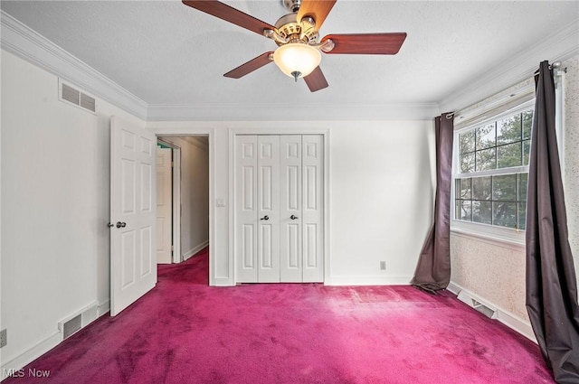 unfurnished bedroom featuring a closet, visible vents, crown molding, and carpet flooring