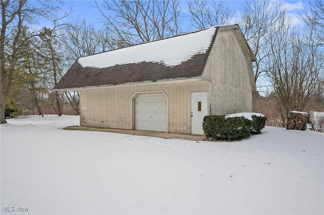 snow covered garage with a detached garage