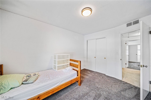 bedroom featuring dark colored carpet, a closet, and visible vents