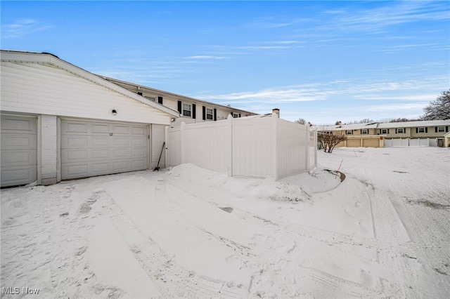 view of snow covered exterior featuring fence