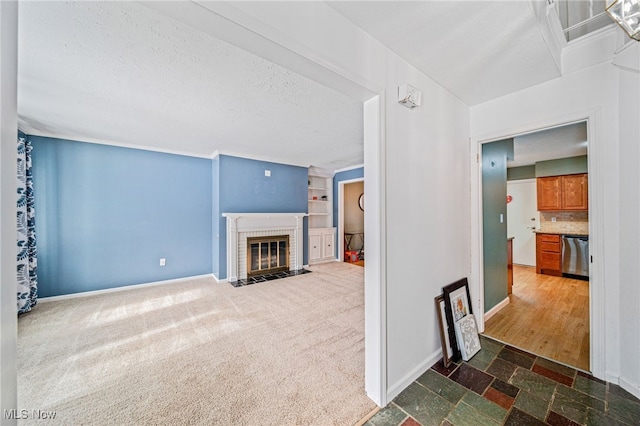 living room featuring dark colored carpet, a brick fireplace, a textured ceiling, and baseboards