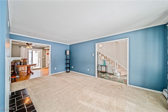 carpeted spare room with stairs, a textured ceiling, a fireplace, and crown molding