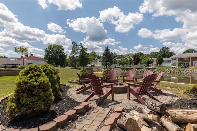 view of patio with a water view, an outdoor fire pit, and a residential view