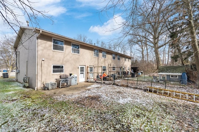 back of house with cooling unit, fence, an outdoor structure, and a storage shed