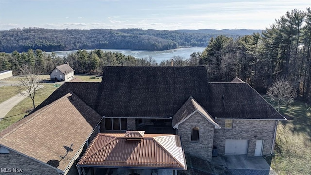 aerial view with a water view and a wooded view