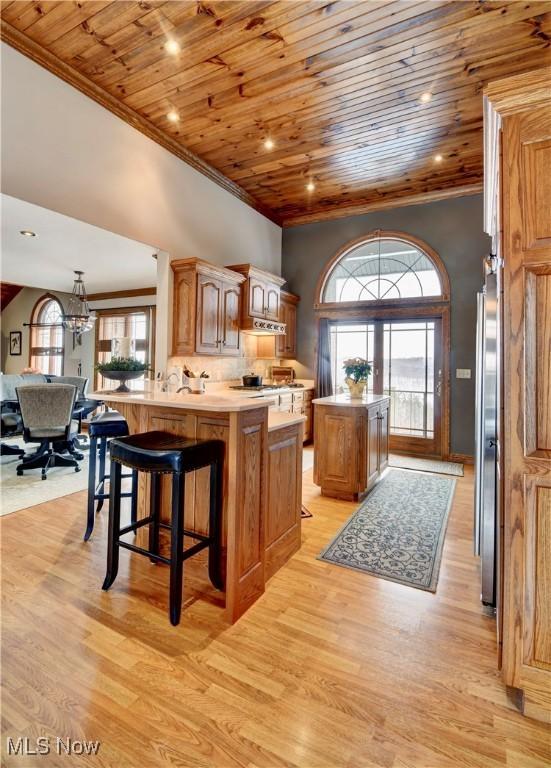 kitchen with wooden ceiling, freestanding refrigerator, light countertops, and a center island