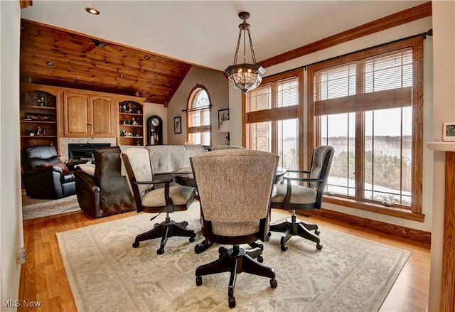 dining area featuring a fireplace, lofted ceiling, an inviting chandelier, light wood-type flooring, and wooden ceiling