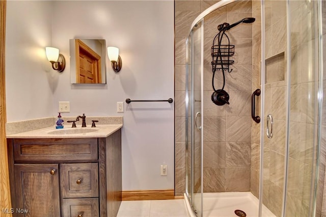 bathroom featuring a stall shower, vanity, and baseboards