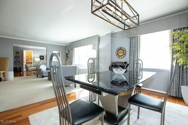 dining room featuring ornamental molding and light wood-style floors