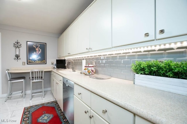 kitchen with light countertops, backsplash, stainless steel dishwasher, and white cabinetry