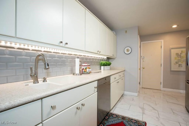 kitchen with marble finish floor, light countertops, stainless steel dishwasher, white cabinetry, and a sink