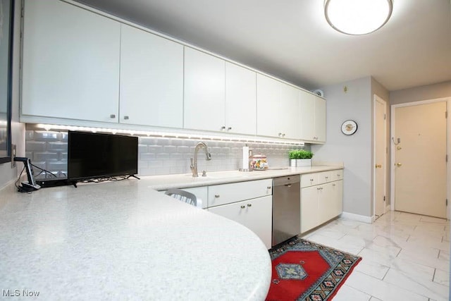 kitchen featuring marble finish floor, light countertops, stainless steel dishwasher, and white cabinetry