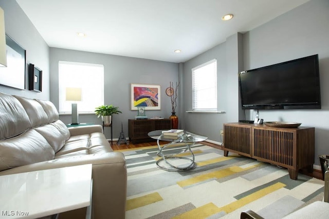 living area featuring light wood-type flooring, baseboards, and recessed lighting