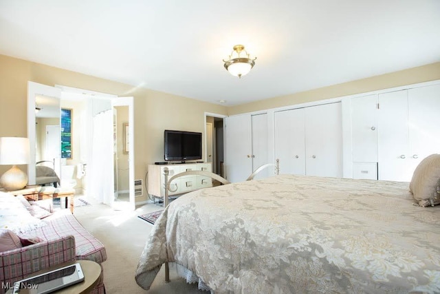 bedroom featuring two closets and light colored carpet