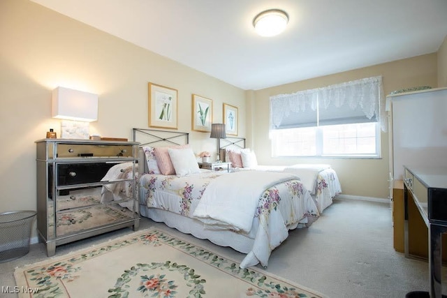 bedroom featuring light carpet and baseboards