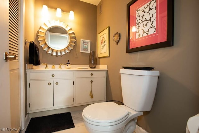 half bath featuring visible vents, vanity, toilet, and tile patterned floors