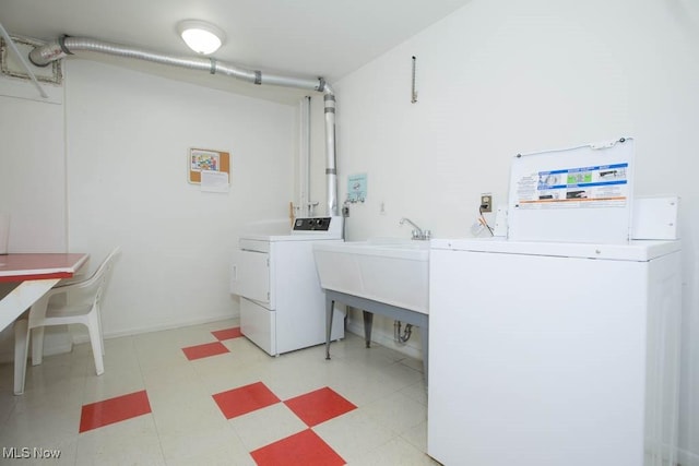 shared laundry area with light floors, washer and clothes dryer, and a sink