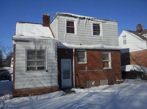 view of front of house with brick siding and a chimney