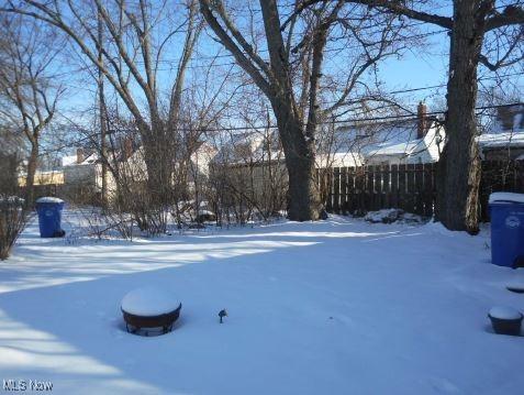 snowy yard featuring fence