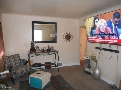 sitting room with arched walkways, carpet floors, and baseboards