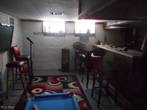 below grade area with a dry bar and billiards