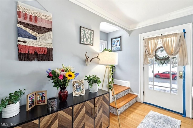 entryway with baseboards, crown molding, stairway, and wood finished floors