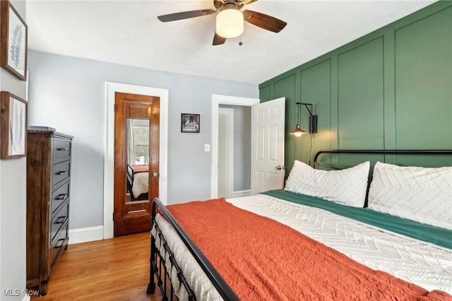 bedroom with light wood-type flooring, ceiling fan, and baseboards